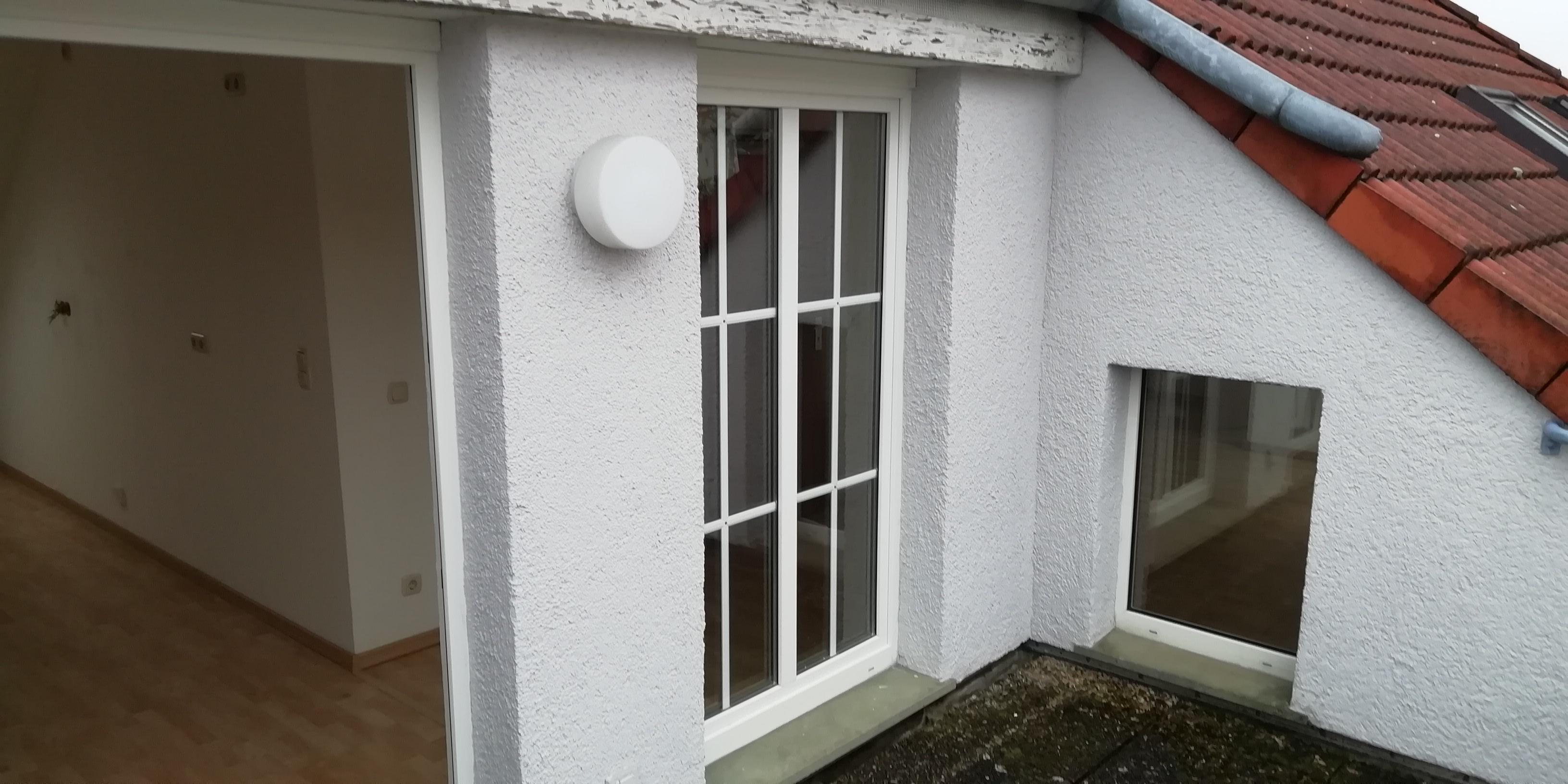  Wohnzimmer mit großen Fenstern, hellem Boden und Zugang zum Balkon